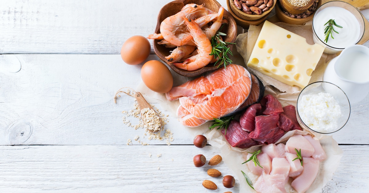 assortment-healthy-protein-source-body-building-food-meat-beef-salmon-shrimp-chicken-eggs-dairy-products-milk-cheese-yogurt-beans-quinoa-nuts-oat-meal-copy-space-background-top-view