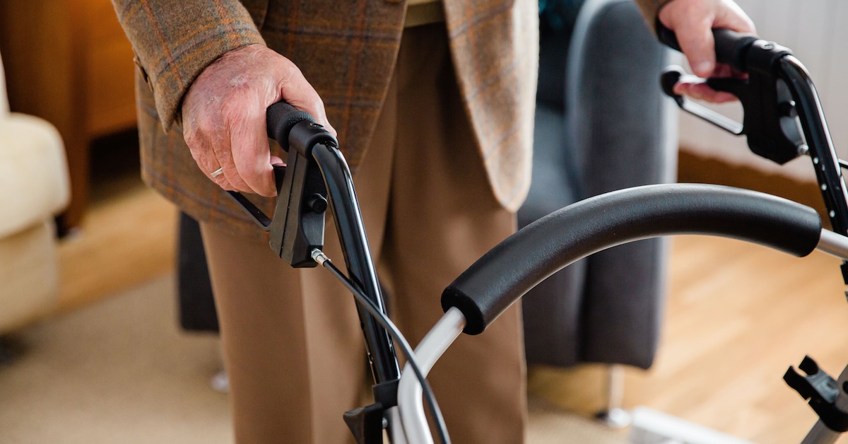 detail-hand-elderly-man-using-walker-get-around-house