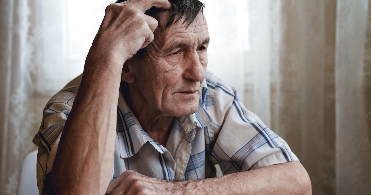 elderly-man-sits-holding-his-head-suffering-from-memory-loss