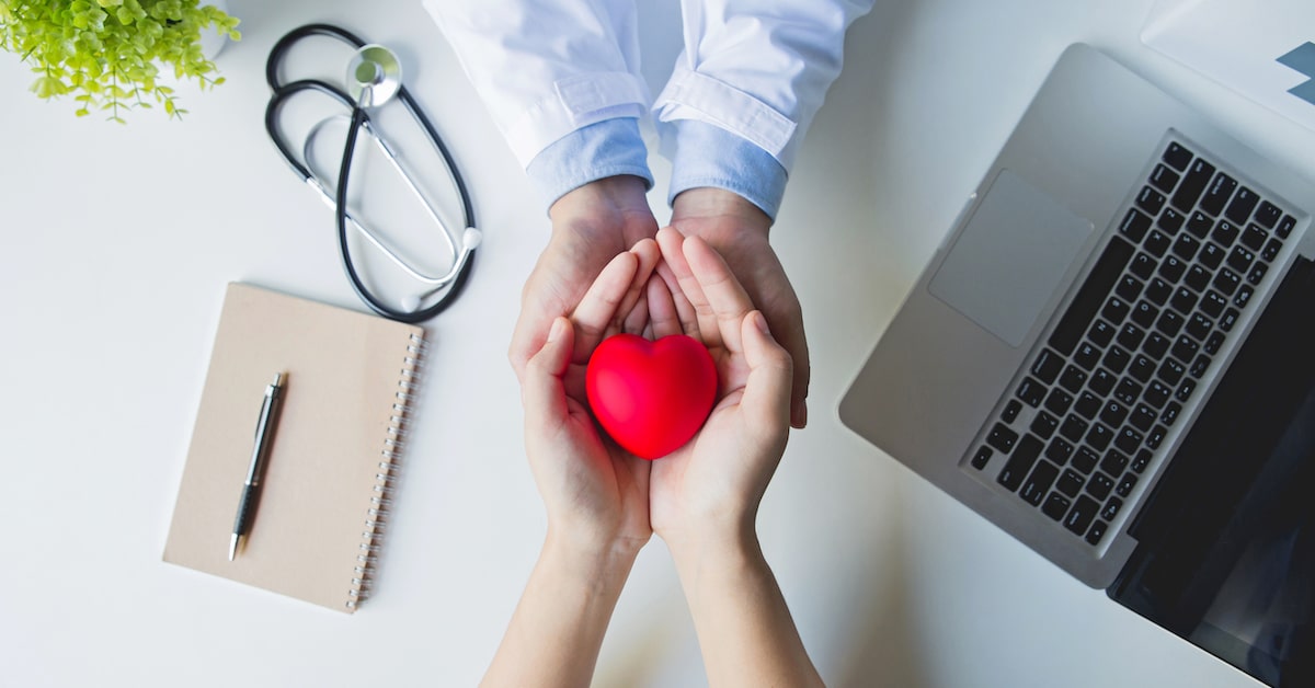 top-view-doctor-patient-hands-holding-red-heart-white-table