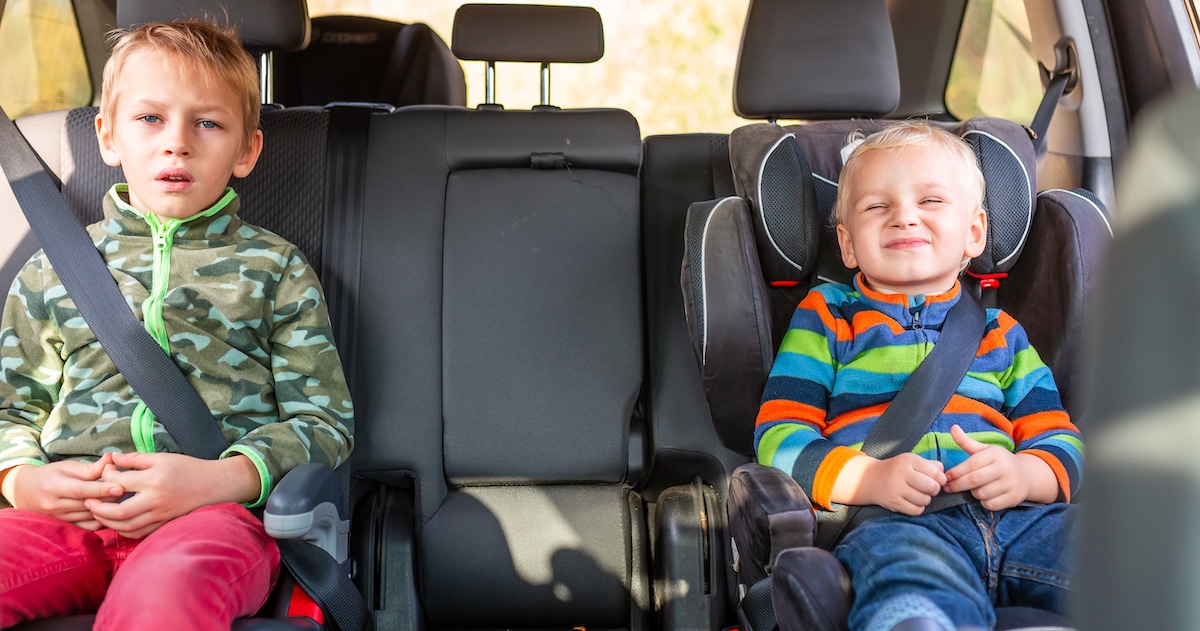 two-little-boys-sitting-car-seat-booster-seat-buckled-up-car