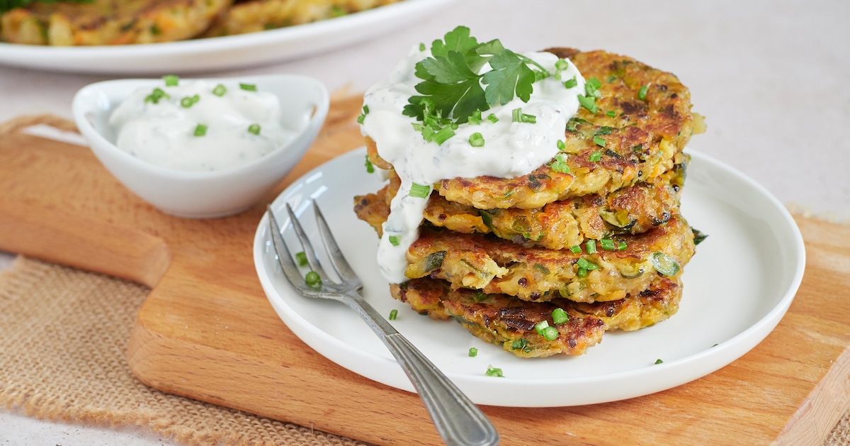 vegetable-fritters-vegetarian-pancakes-served-pile-white-plate-with-sour-cream-fresh-herbs
