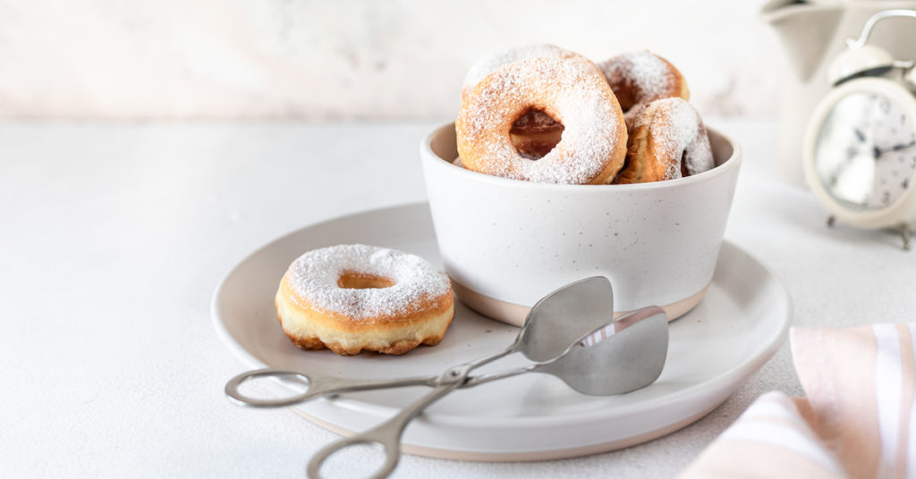 traditional-breakfast-doughnut-with-sugar-milk-coffee-white-background-selective-focus-1024x536