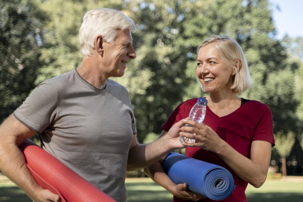 smiley-older-couple-outdoors-with-yoga-mats-water-bottle-1024x683